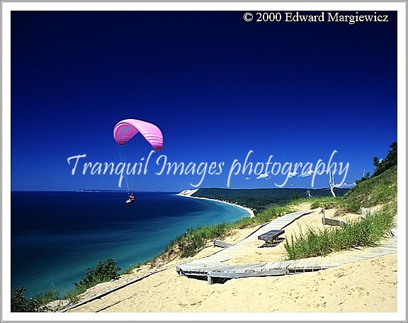 350123---A paraglider hovering over Lake Michigan and the Sleeping Bear Dunes. The Dunes are 900 feet above Lake Michigan at this point